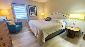 A bedroom with a bed, a chair, a dresser, and a window with blinds. - Country Apartment Rental in an Outdoor Paradise! (Mount Carroll)