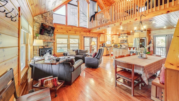 A spacious cabin with a loft bedroom, a dining area, a kitchen, and a living room with a fireplace. - Waterfront Watauga Lake Home w/ Private Dock! (Butler)