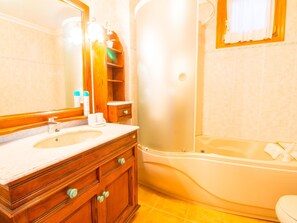 A bathroom with a wooden vanity, a sink, and a bathtub. - Sunny villa with private pool, A/C and WIFI (Pollença)