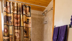 A bathroom with a shower curtain, a bathtub, a toilet, and a sink. - Located by the River facing the Mountains (Red River)