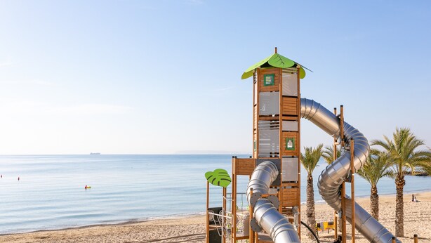 A beach with a play structure, palm trees, and a clear sky. - Apartment 'Urbanización Las Torres' with Sea View, Wi-Fi and Air Conditioning (Alacant)