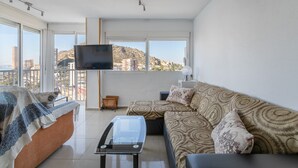A modern living room with a sofa, a coffee table, and a TV mounted on the wall. - Apartment 'Urbanización Las Torres' with Sea View, Wi-Fi and Air Conditioning (Alacant)