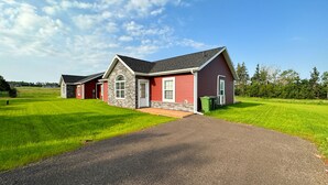 Een woonhuis met twee verdiepingen, een rode gevel en stenen details, een voortuin en een verzorgd gazon.