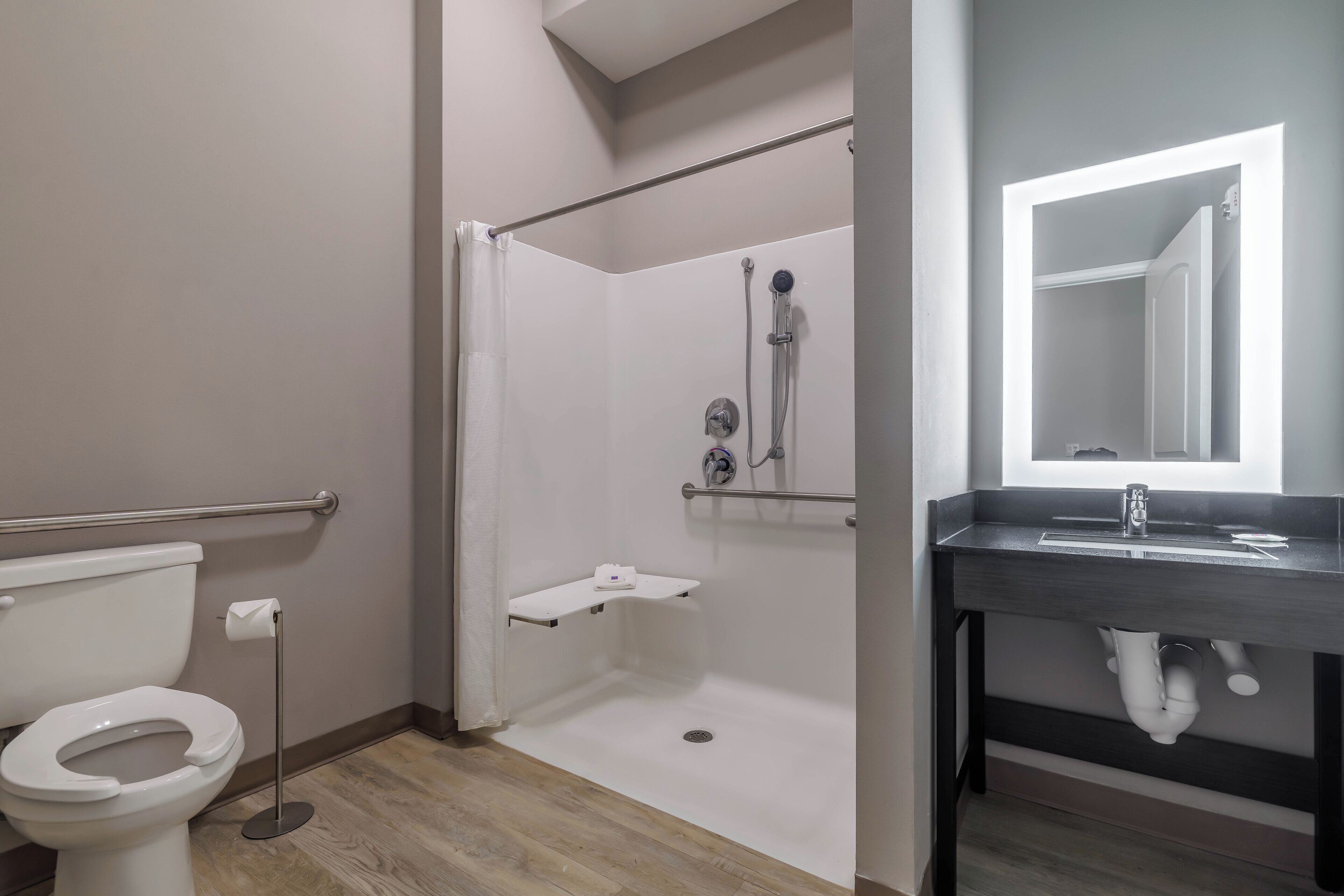 Et moderne badeværelse med toilet, bruser og vask.