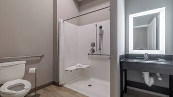 Et moderne badeværelse med toilet, bruser og vask.