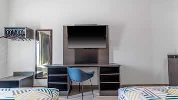 Ein Schlafzimmer mit Bett, Schreibtisch, Stuhl, Fernseher und Kleiderschrank.