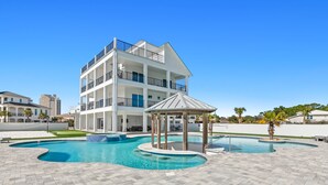 Un edificio moderno de varios pisos con piscina y un pabellón.