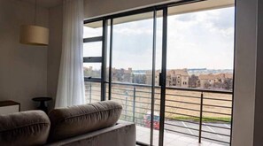 Relax in this stylish living room with a balcony offering a city view.