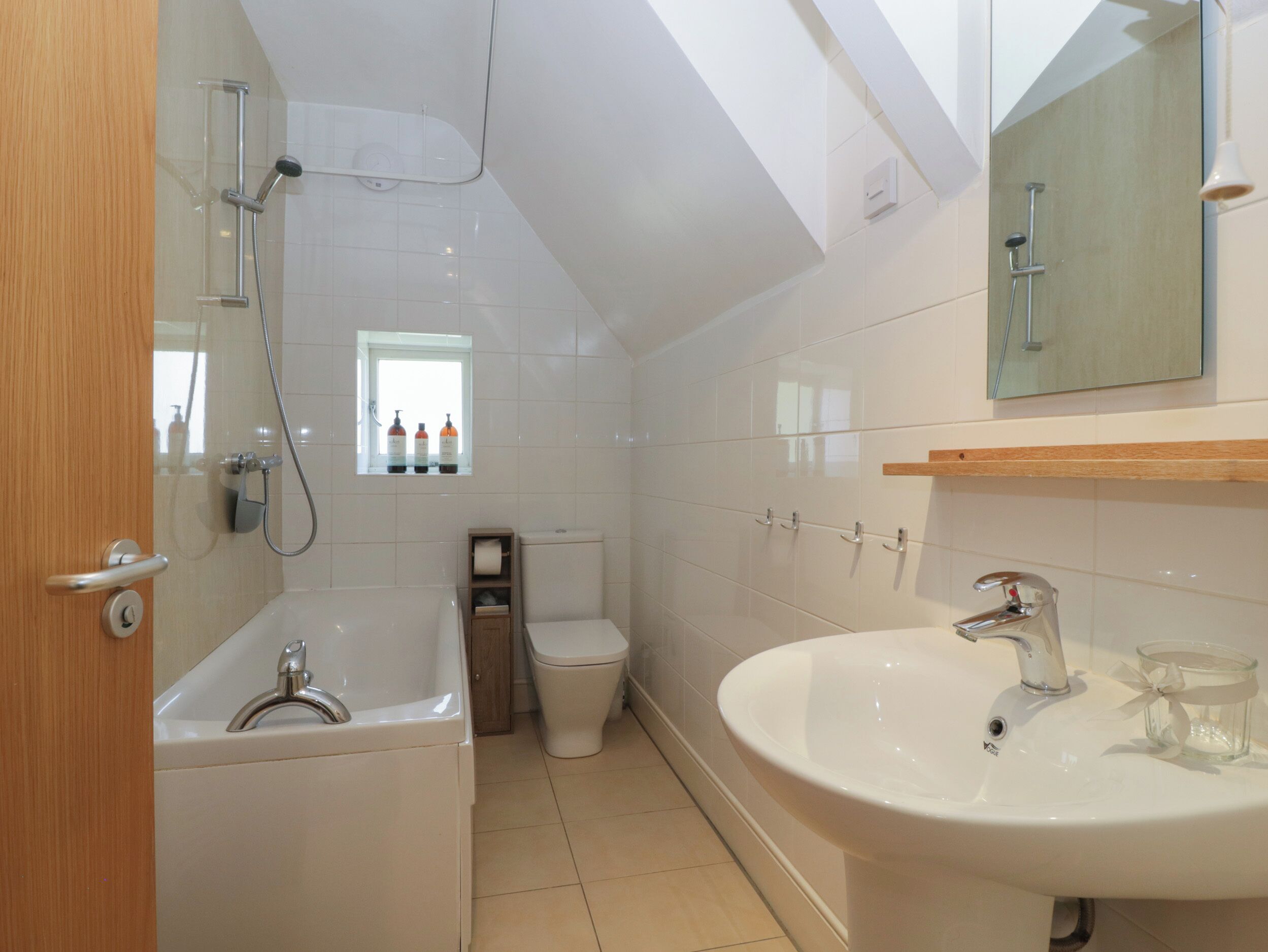 A modern bathroom with a bathtub, toilet, and sink.