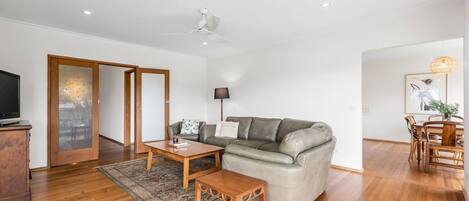 Ein modernes Wohnzimmer mit Sofa, Couchtisch und Fernsehschrank.