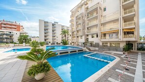 A modern hotel with a swimming pool, multiple balconies, and a well-maintained outdoor area. - 'Salou Beach' Apartment with Sea View, Wi-Fi and Air Conditioning (Salou)