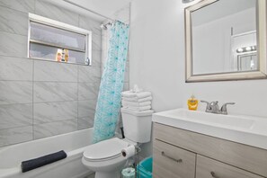 A modern bathroom with a bathtub, toilet, and sink.