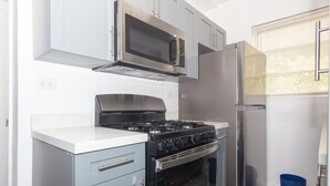 A compact kitchen with a gas stove, oven, microwave, and refrigerator. - Deco Apt w/2 Queen Beds on Ocean Dr, South Beach (Miami Beach)