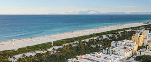 Une plage avec une rangée de bâtiments au premier plan.