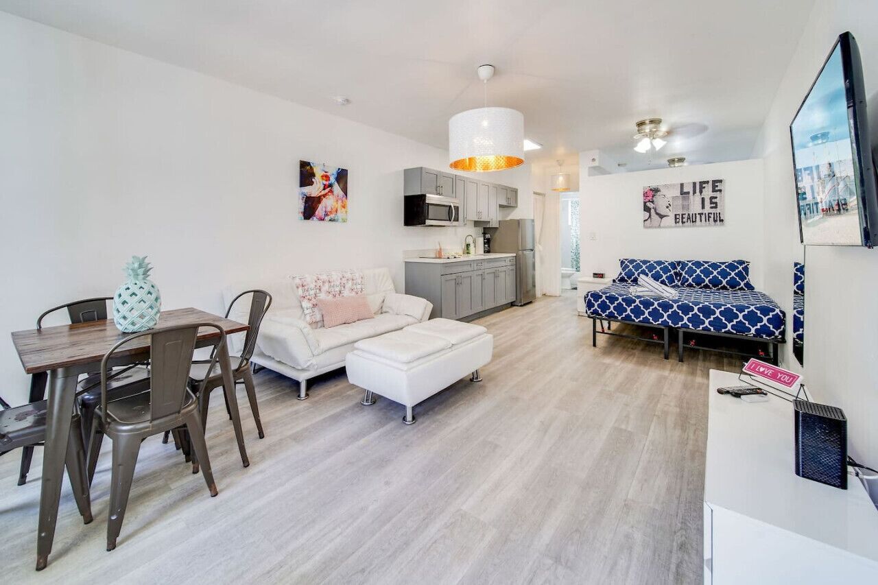 A modern apartment with a dining area, kitchen, and living space.