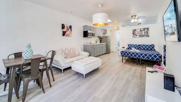 A modern apartment with a dining area, kitchen, and living space.
