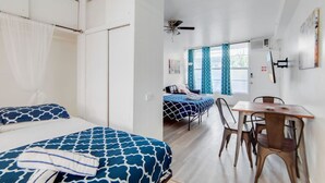 A room with two beds, a dining table, and a ceiling fan. - Ocean Drive Best Deal, w/2 Queen Beds, Near Beach (Miami Beach)
