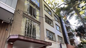 A multi-story building with a ground-level entrance, a covered outdoor seating area, and a balcony with metal railings. - Condesa Residence Campeche 276 (Mexico City)