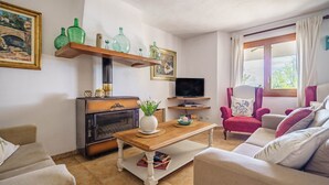 A living room with a fireplace, a television, a sofa, and a coffee table.