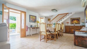 A spacious dining area with a wooden staircase, a dining table, and chairs.