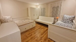A bedroom with a bed, a sofa, a wardrobe, and a nightstand. - Charmante 2-zimmer-wohnung (Siegen)