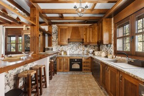 Una cocina con armarios de madera, encimera de granito, horno empotrado y ventana.