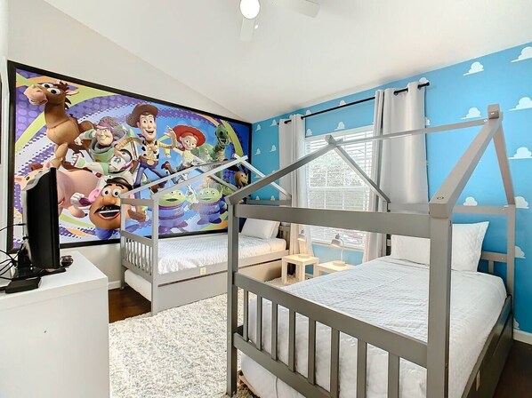A bedroom with bunk beds, a TV, and a mural of animated characters. - Cinderella's Castle - Disney Themed Townhome (Kissimme)