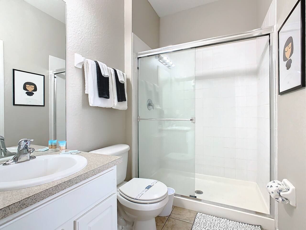 A bathroom with a sink, toilet, and glass-enclosed shower.