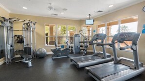 Un gimnasio con cintas de correr, máquinas de pesas y una bicicleta estática.