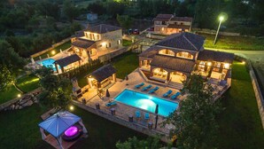 Ein großzügiges, helles Wohnanwesen mit Pool, mehreren Häusern und einer Terrassenfläche.