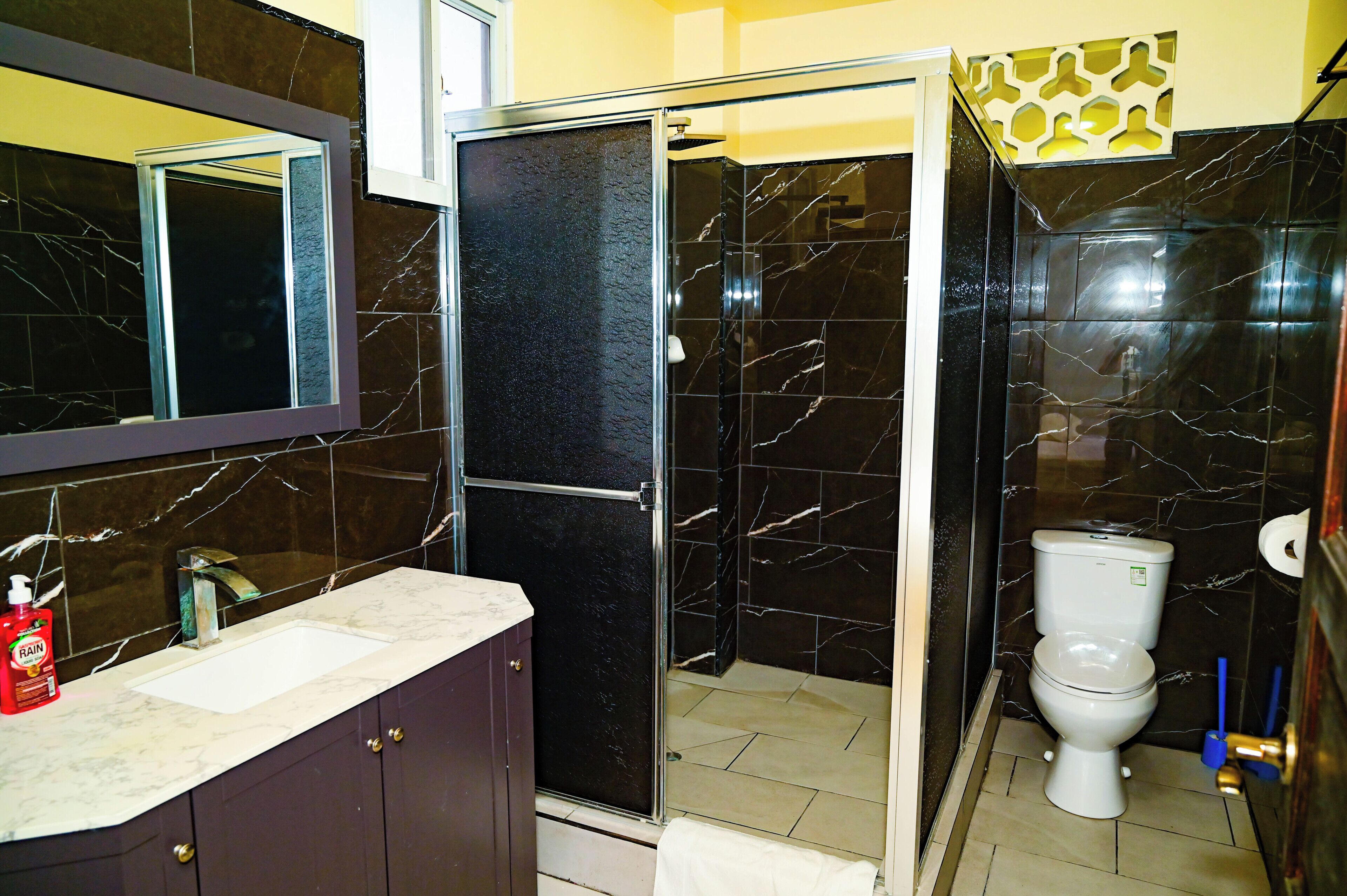 Un baño con ducha, inodoro y lavamanos.