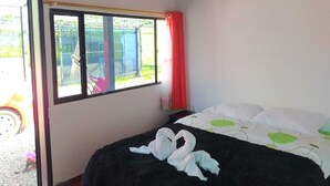 Een slaapkamer met een bed, een raam en uitzicht op de omgeving.