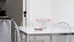 A modern kitchen with a white countertop, a glass cabinet, and a white appliance. - Eva Apartment, a stone's throw from the sea (San Vito Lo Capo)