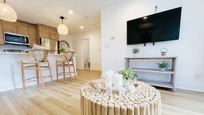 Una cocina moderna con armarios de madera, un microondas y una lámpara colgante.