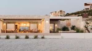 Une maison moderne dotée d’un patio aménagé avec un espace salon extérieur.
