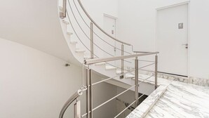 Una escalera moderna y curvada con barandillas de metal que conduce a una plataforma.