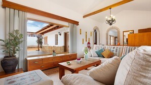 A living room with a sofa, coffee table, wooden cabinet, and a large mirror. - Vacation Home 'Casa Glory' with Mountain View, Wi-Fi and Air Conditioning (Antigua)