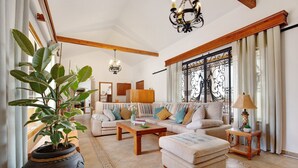 A spacious living room with a sofa set, a coffee table, a potted plant, and a chandelier. - Vacation Home 'Casa Glory' with Mountain View, Wi-Fi and Air Conditioning (Antigua)