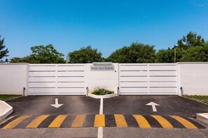 A gated parking area with directional arrows on the ground.