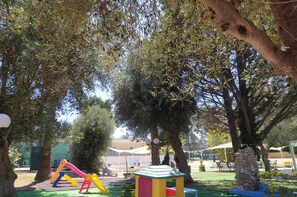 Une aire de jeux avec des structures d’escalade et une petite maison de jeu.