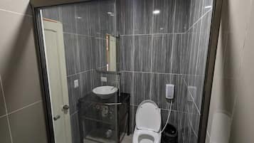 A modern bathroom with a glass-enclosed shower, a white toilet, and a vanity with a sink.