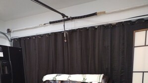 Une chambre à coucher avec un lit, un canapé, une armoire et un rideau.