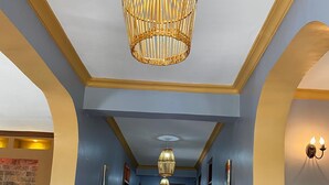 A hallway with a tiled floor, blue walls, and a wooden door at the end.