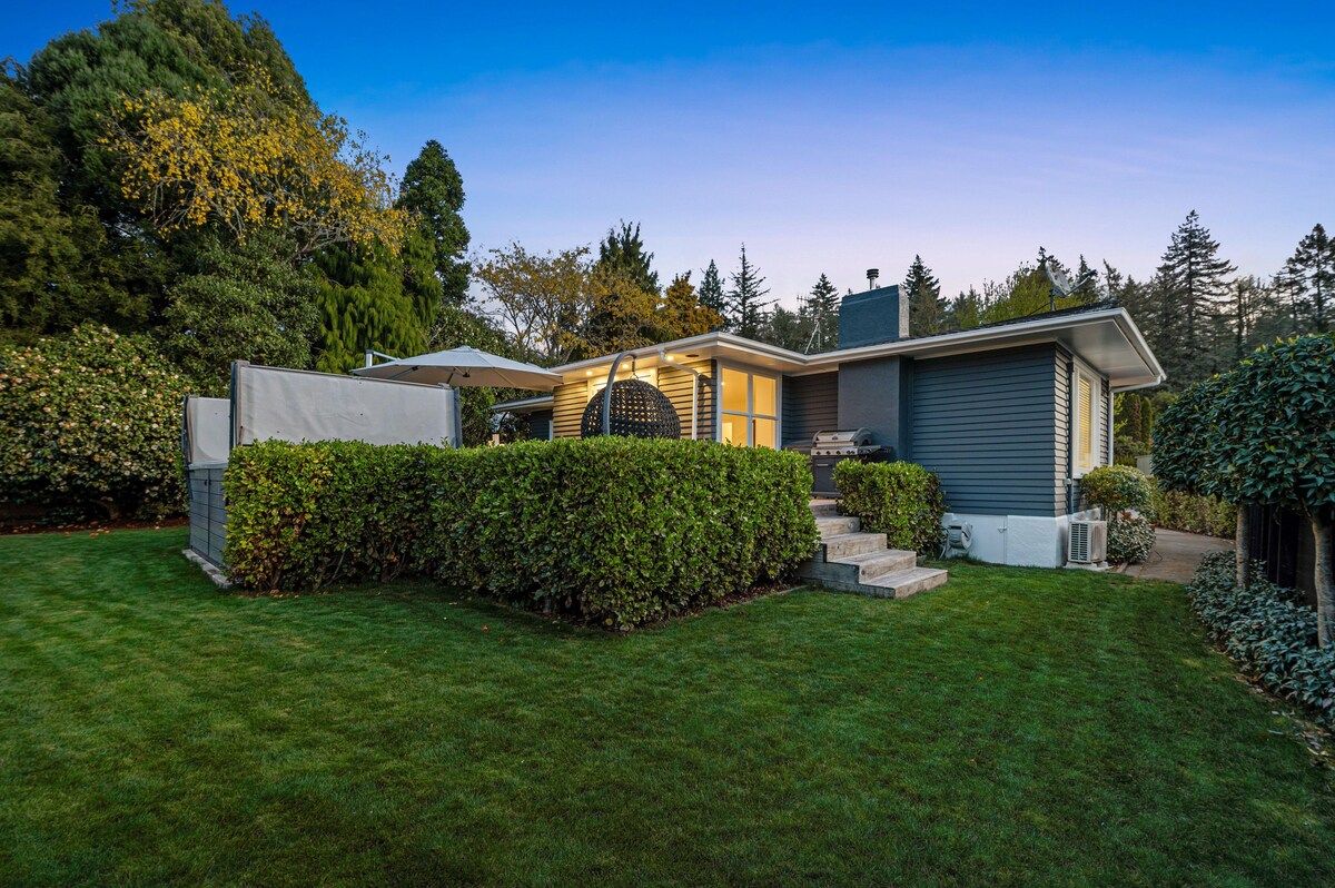 A modern house with a well-maintained lawn, a covered patio, and a garage.
