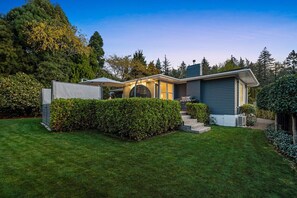 A modern house with a well-maintained lawn, a covered patio, and a garage.