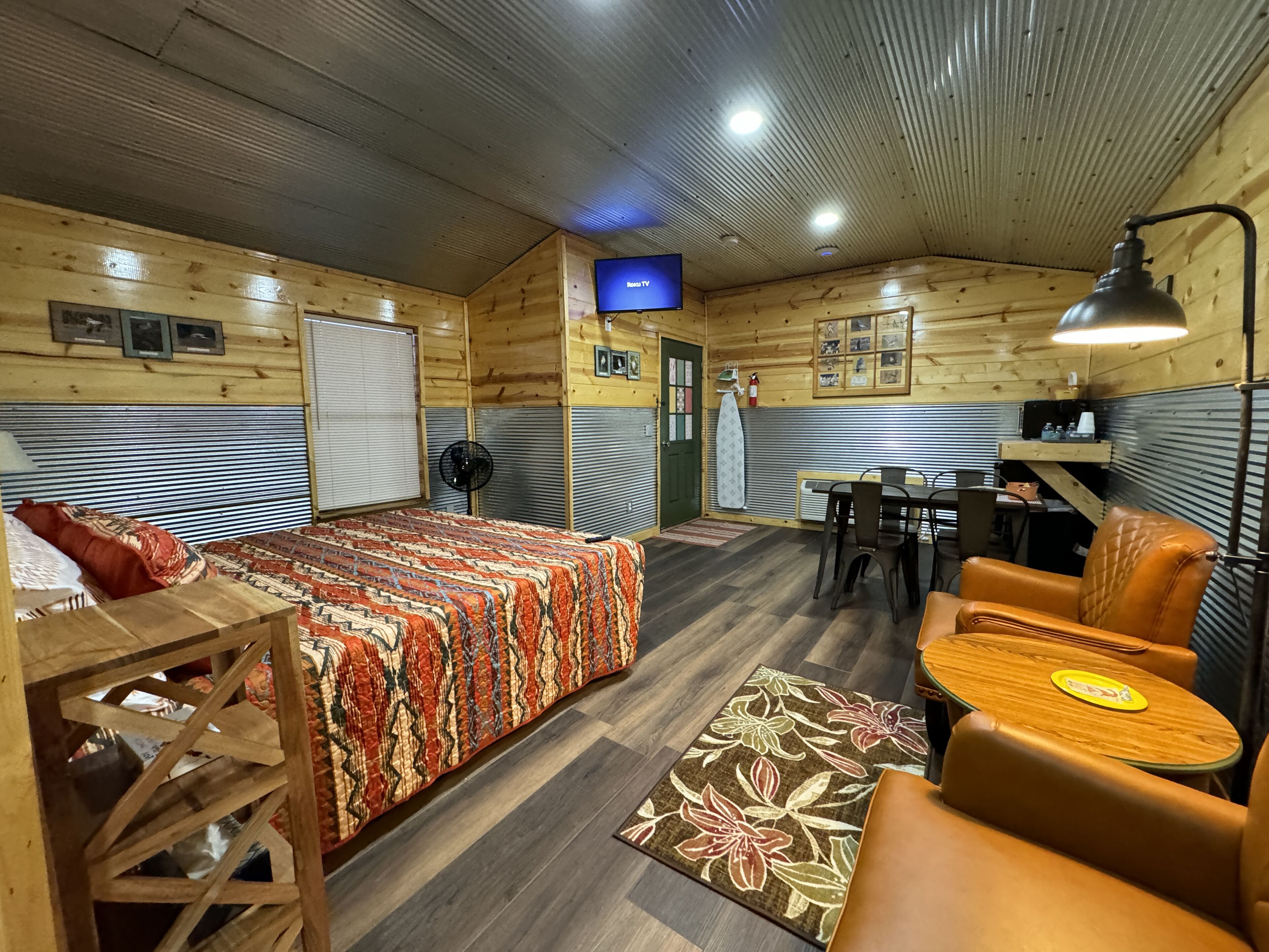 Een knus vertrek met een bed, een bureau en een eethoek.