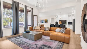 Ein modernes Wohnzimmer mit einer Ledersofa, einem Couchtisch und einem Teppich.
