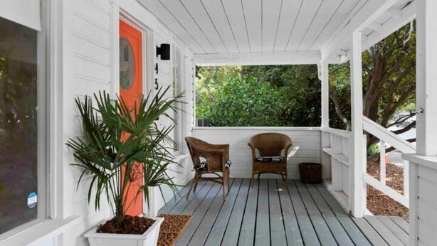 A covered porch with white railings, two wicker chairs, and a potted plant. - Fox at Fourth Street Walk to downtown Chico (Chico)