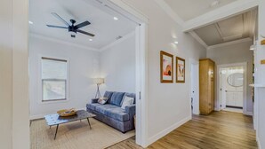 A spacious living area with a sofa, coffee table, and ceiling fan. A kitchen is visible in the background. - Located in Northtown Arcata, The Yellow Doors `A` (Arcata)