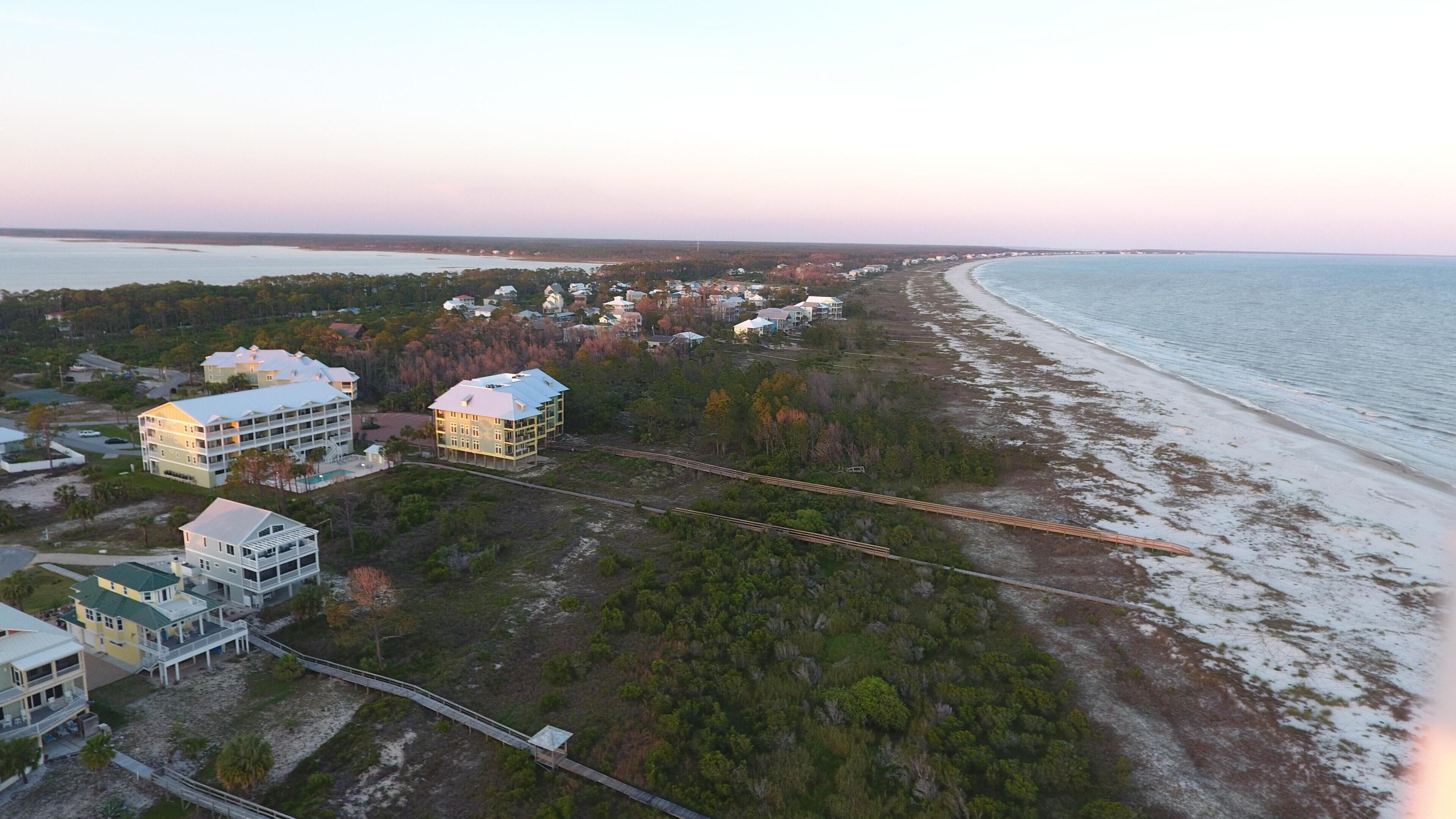 Une vue aérienne d’une zone côtière avec de nombreux bâtiments, une plage et un pont.